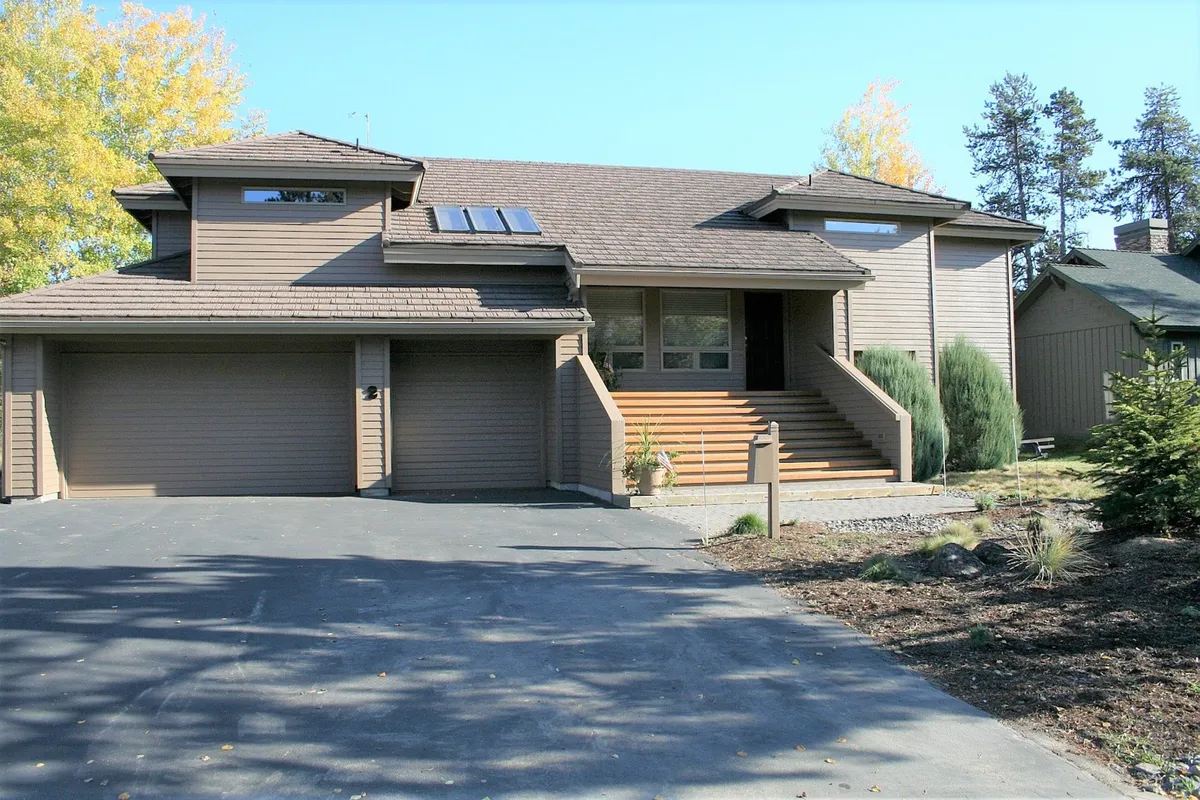 This exterior shot captures the home's inviting front entrance with a staircase, large windows, and a landscaped area, suggesting both accessibility and a welcoming atmosphere for families coming and going. The visible porch hints at relaxing outdoor moments and the home's connection to neighborhood adventures.